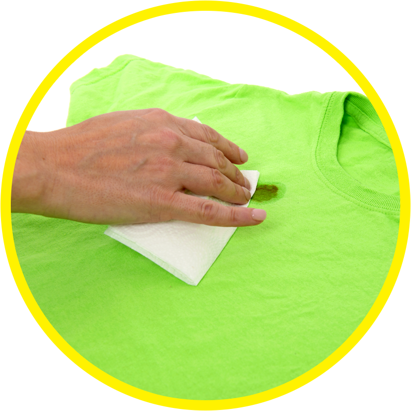 Green shirt with stain being wiped with a paper towel